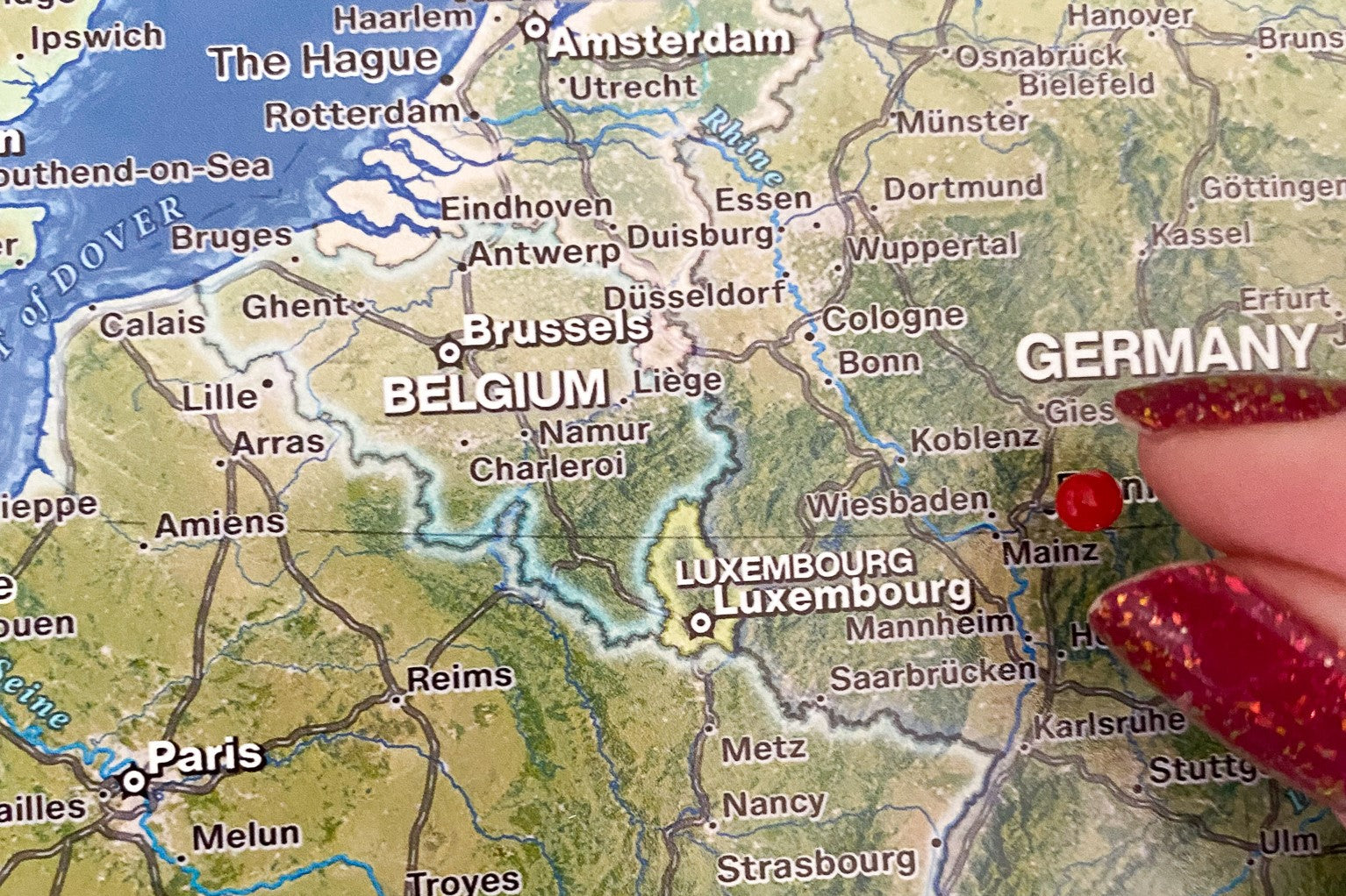 person pinning a european push pin travel map in germany