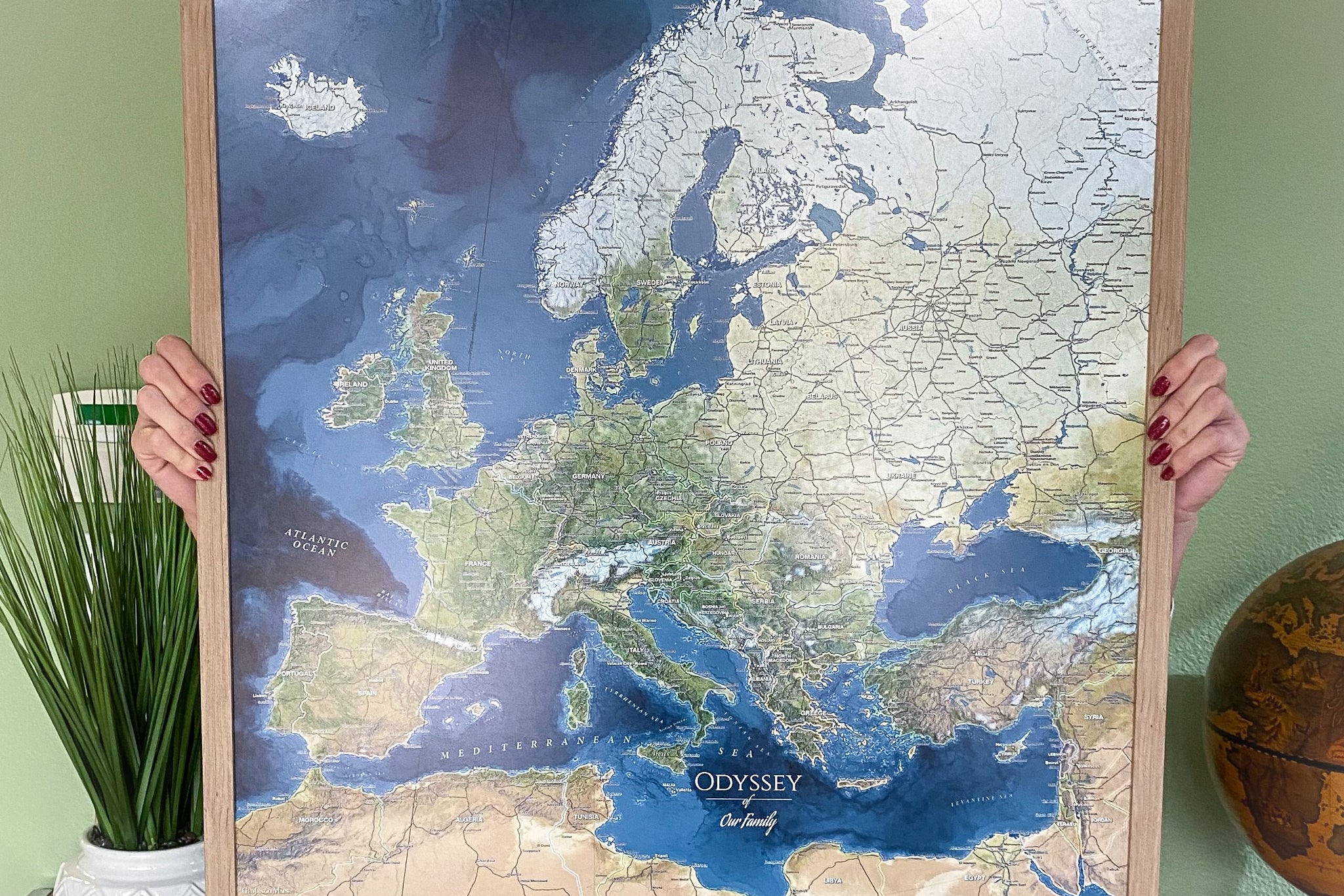 person holding a paper framed push pin travel map voyager