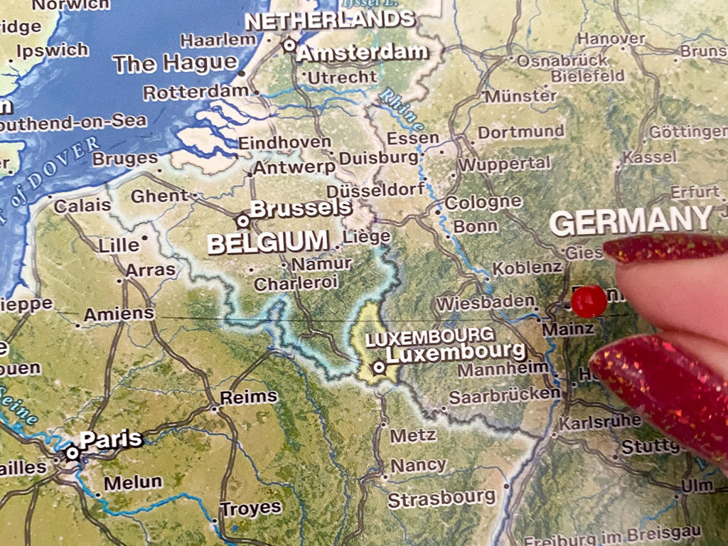 person pinning a european push pin travel map in germany