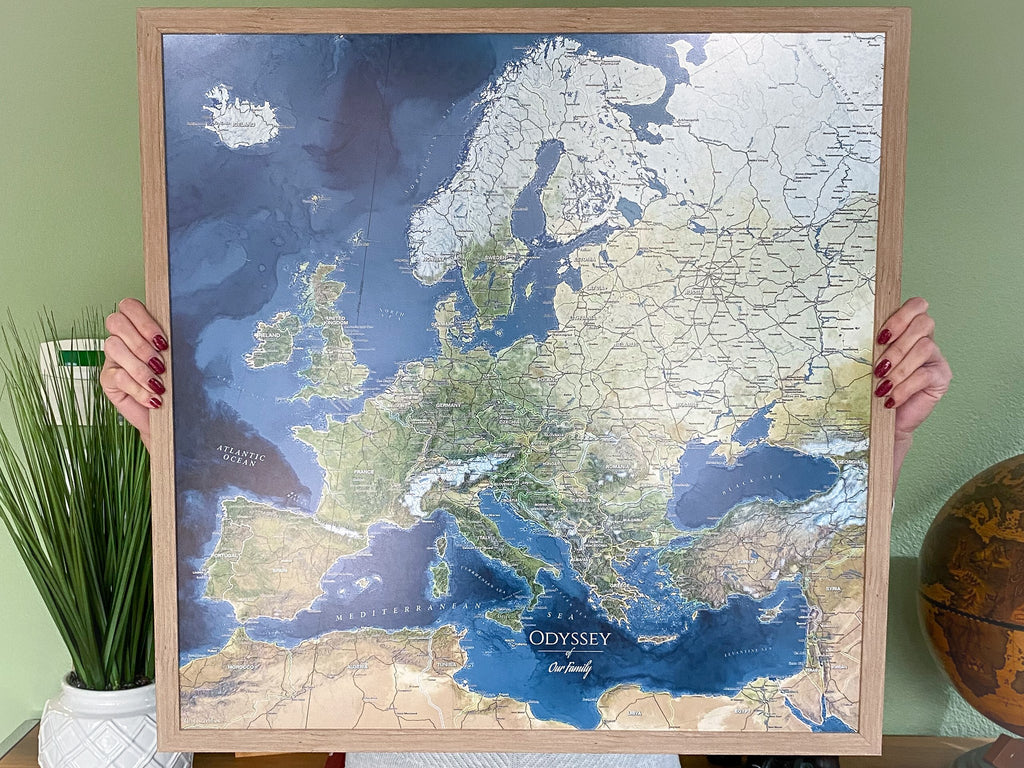 person holding a paper framed push pin travel map voyager