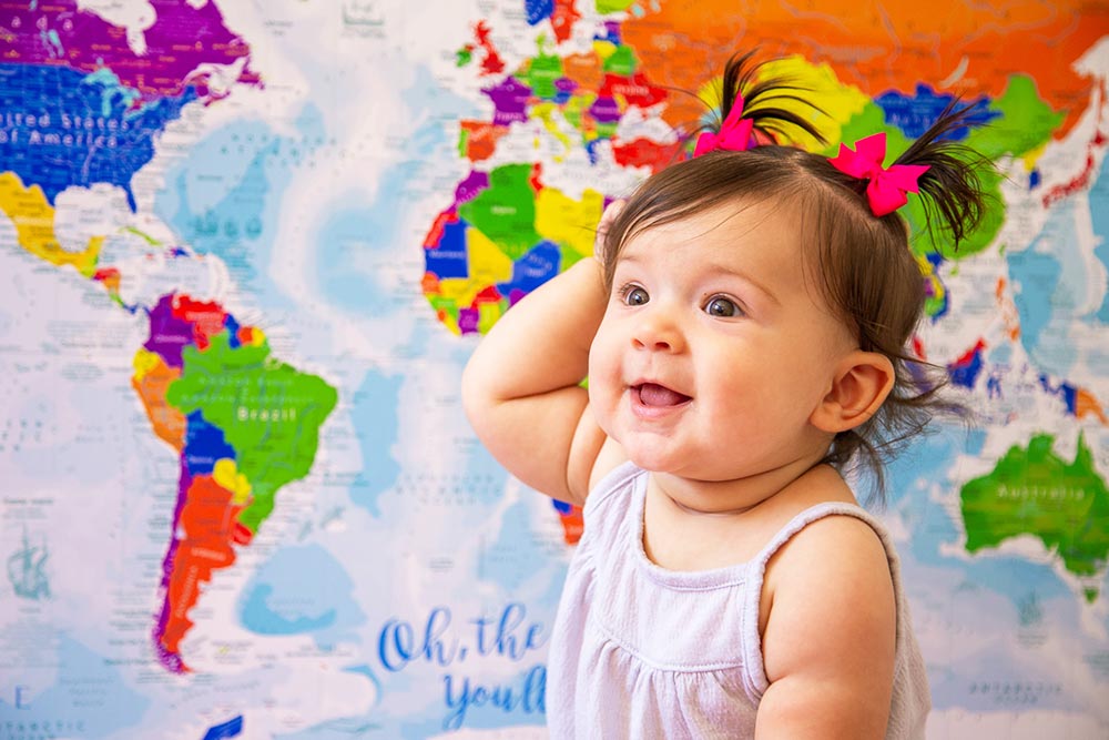 Child in front of a map of the world labeled for learning
